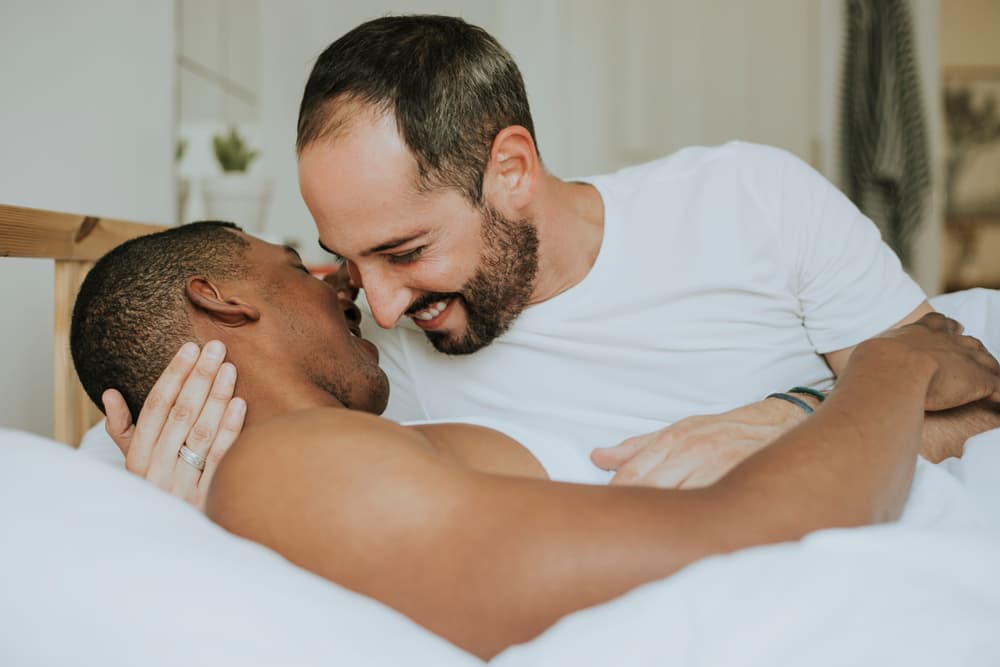 Two men in white t-shirts embracing